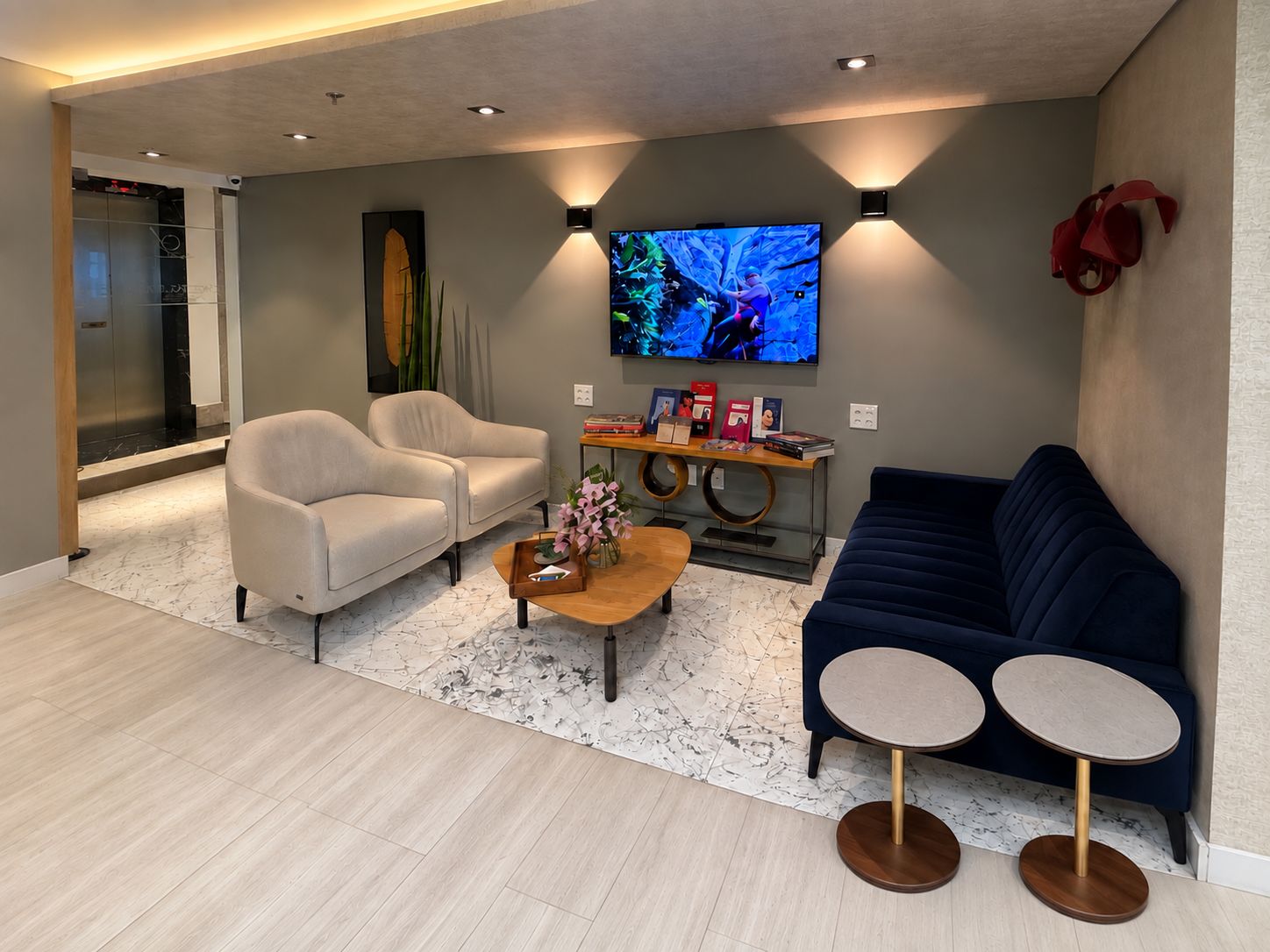 Sala de espera da clínica, com poltronas, sofá e a entrada ao fundo