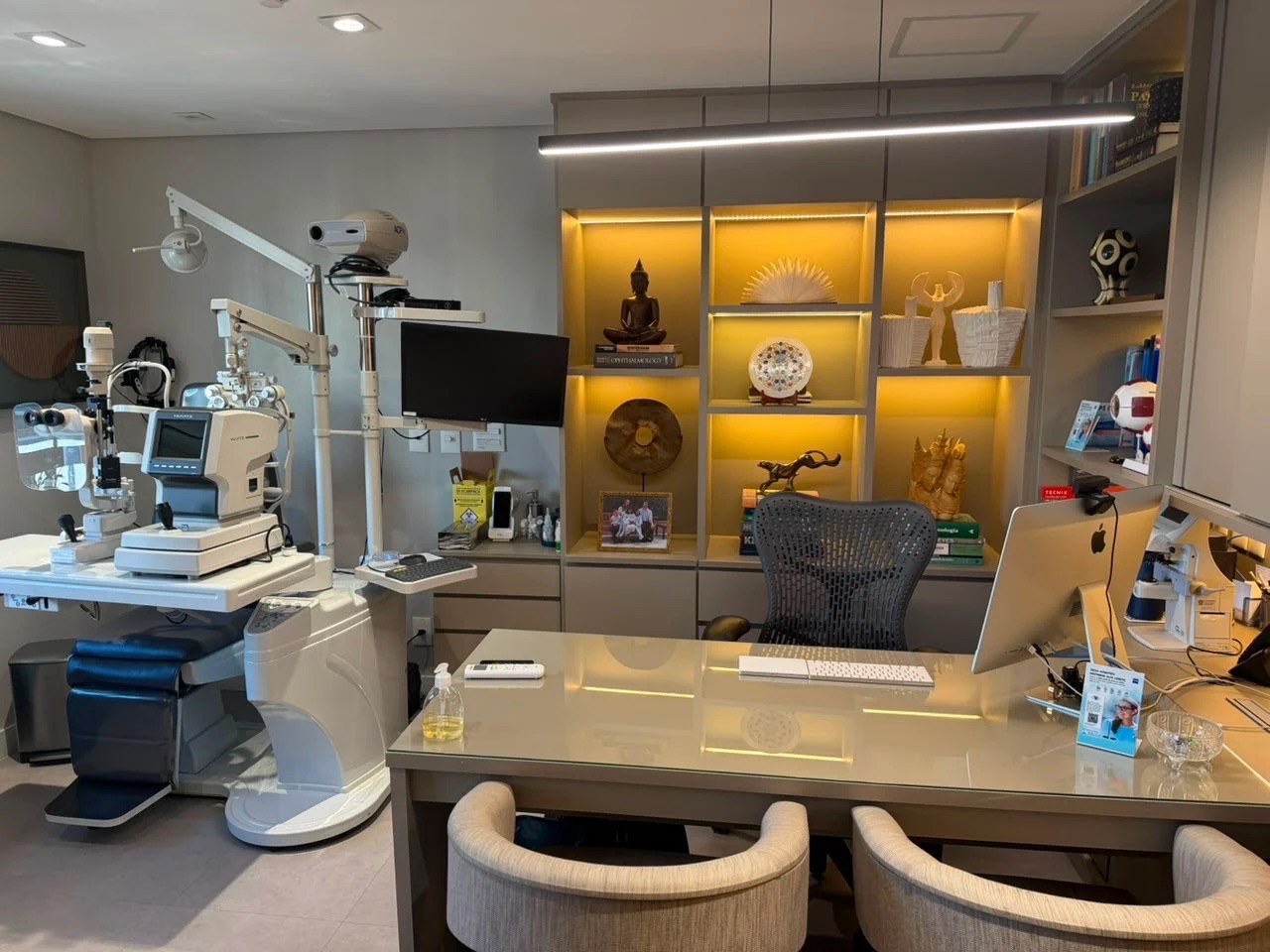 Sala de exames com lâmpada de fenda e autorrefrator ao lado da mesa de atendimento